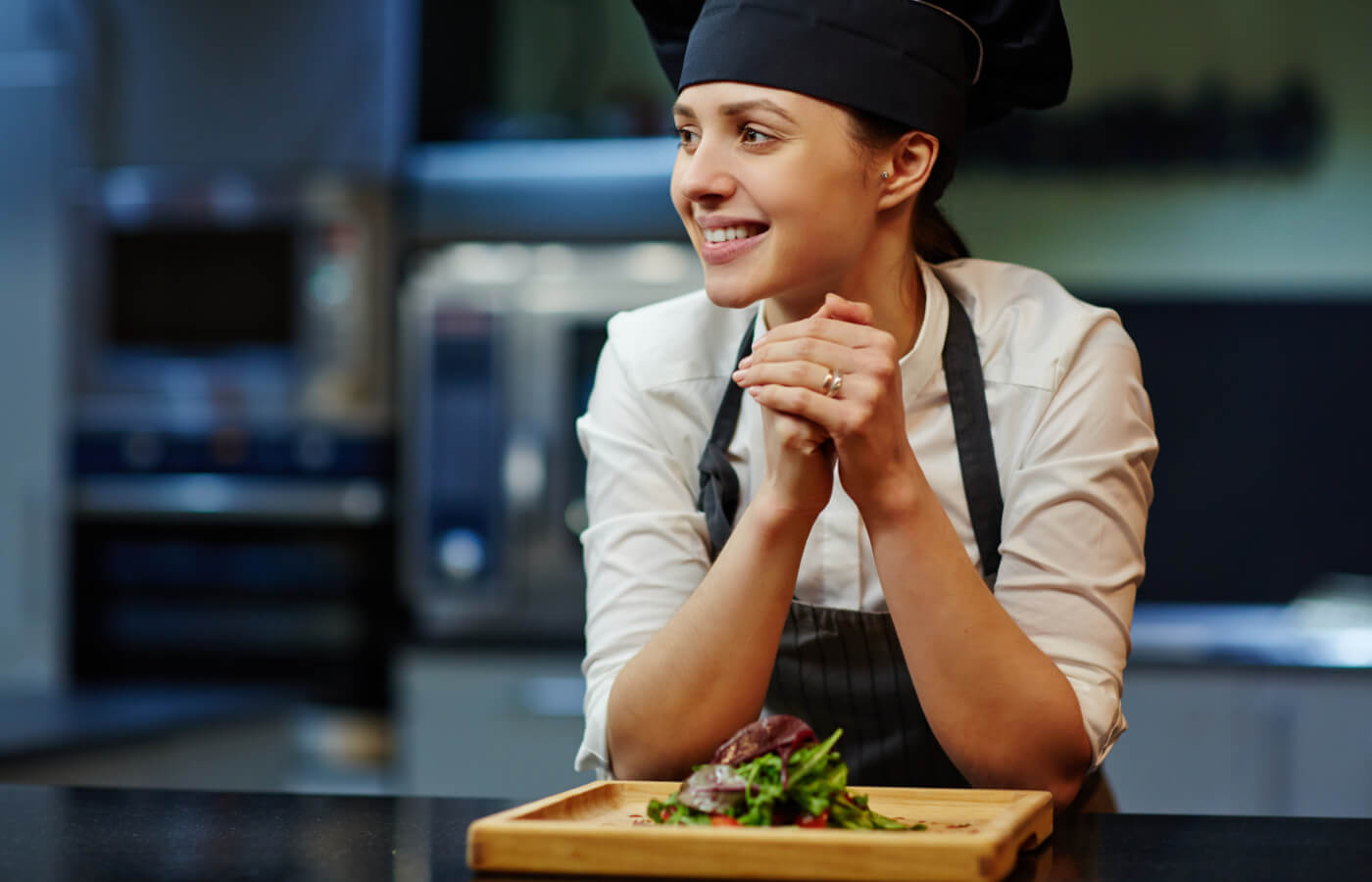 Junge Köchin richtet einen Salat an