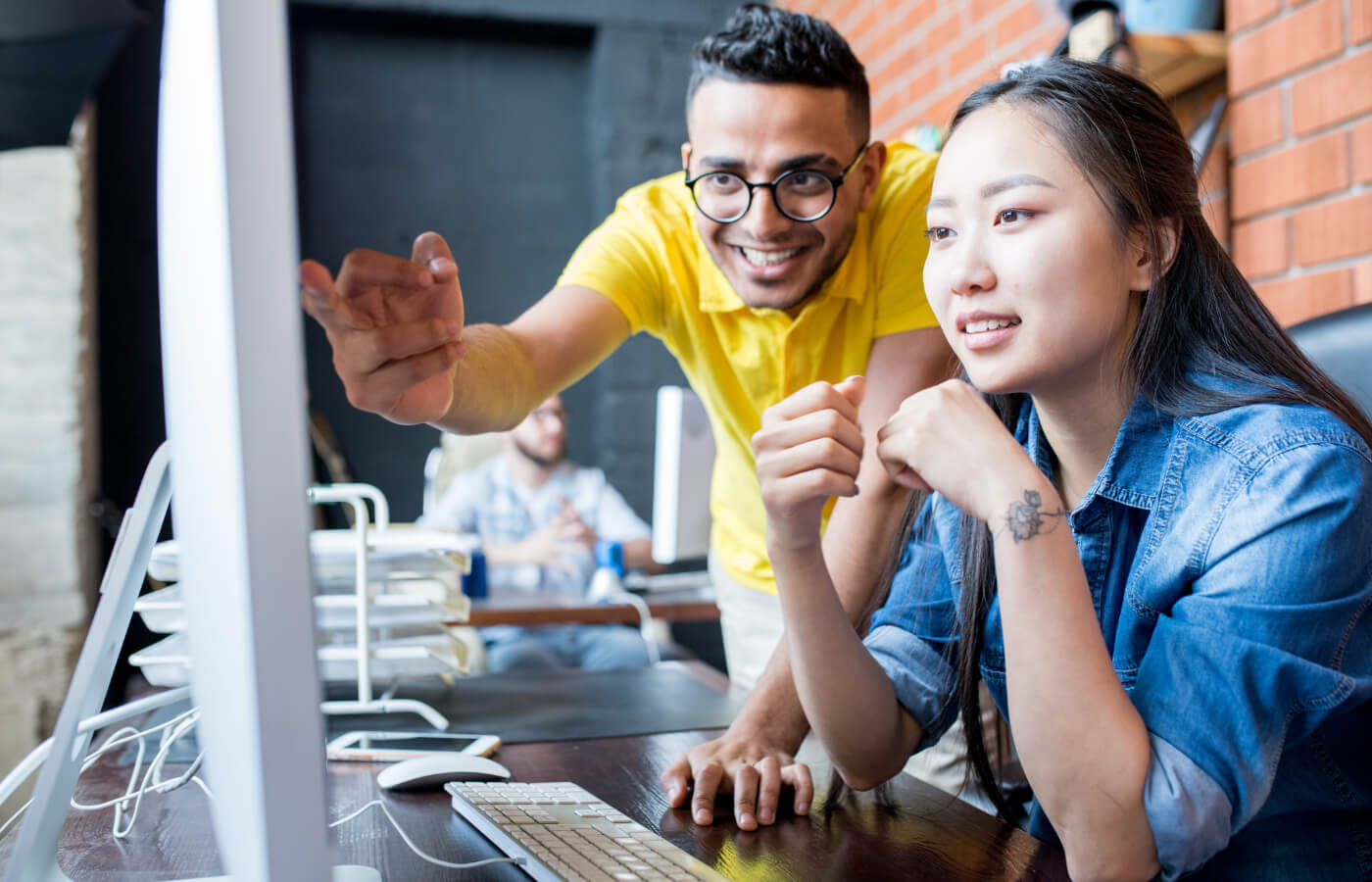 Zwei Auszubildene besprechen etwas am PC